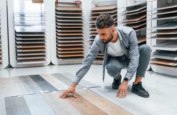Looking for parquet. Stylish beautiful man is in the store of goods for the home Looking for parquet. Stylish beautiful man is in the store of goods for the home.