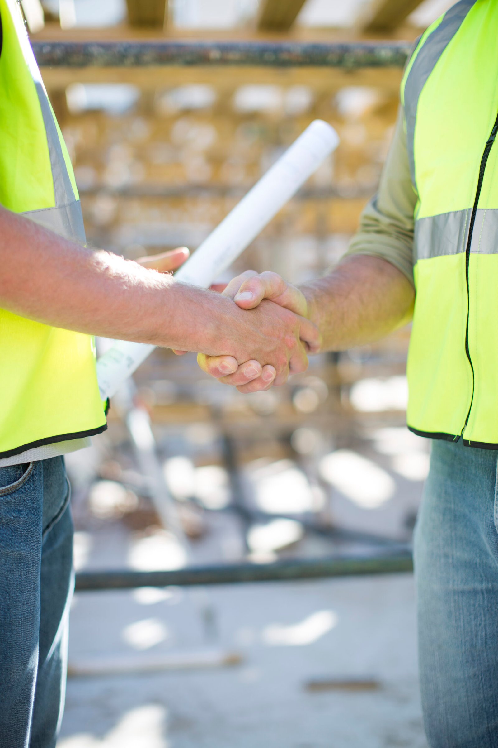Two construction workers shaking hands in construction site Two construction workers shaking hands in construction site